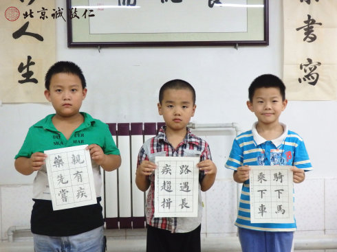 書法二班的小學(xué)員展示定心描紅習(xí)作