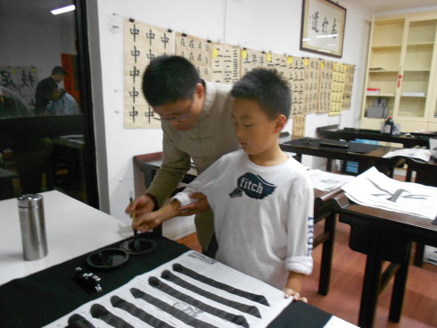 老師在教我們?nèi)绾握耗驼{(diào)筆