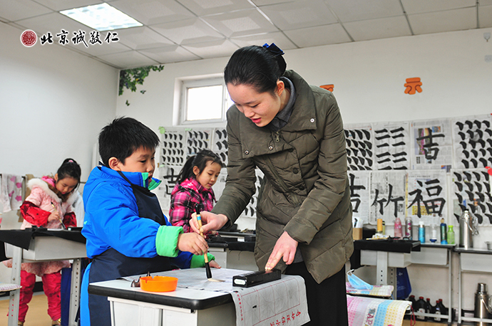 書法老師認真指導小學員習書