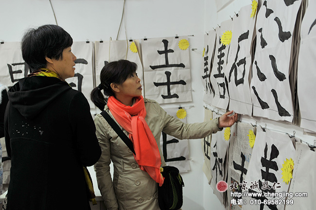 老師們在觀摩研討少年班孩子們的書法作品。