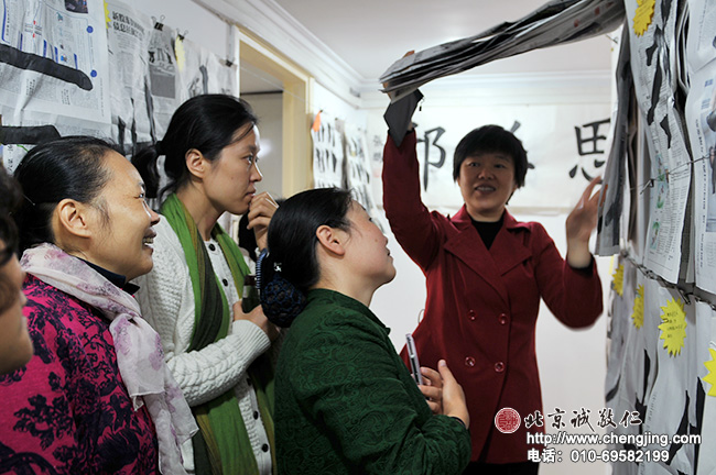 林老師向大家介紹書法班里一位學員的作品，大家都在為這位學員驚人的進步而感慨！